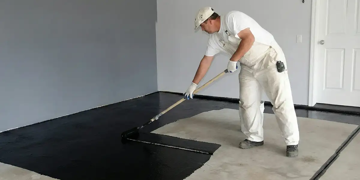 basement waterproofing professional applying waterproof coating to protect a basement floor in San Antonio, TX