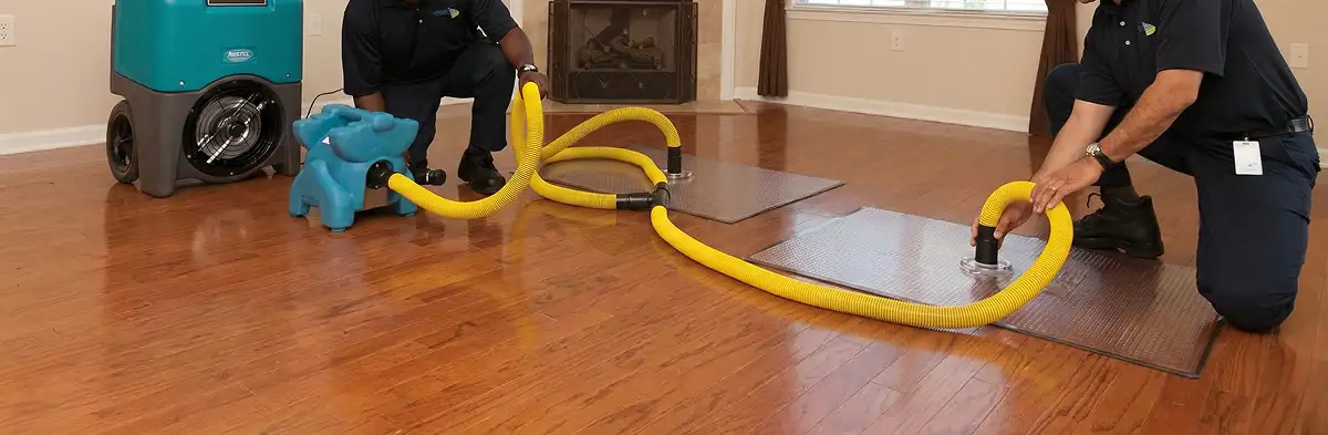 emergency water removal technicians extracting standing water from a home using professional equipment in San Antonio, TX